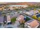 Expansive aerial view of a home, displaying lush greenery, a tranquil lake, and the city skyline beyond at 18103 W Canyon Ln, Goodyear, AZ 85338
