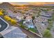 Scenic aerial view showcasing a home's backyard oasis with a sparkling pool and verdant putting green at 18103 W Canyon Ln, Goodyear, AZ 85338