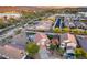 Expansive aerial view of a home, displaying lush greenery, a tranquil lake, and the city skyline beyond at 18103 W Canyon Ln, Goodyear, AZ 85338