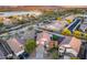 Expansive aerial view of a home, displaying lush greenery, a tranquil lake, and the city skyline beyond at 18103 W Canyon Ln, Goodyear, AZ 85338