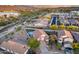 Expansive aerial view of a home, displaying lush greenery, a tranquil lake, and the city skyline beyond at 18103 W Canyon Ln, Goodyear, AZ 85338