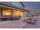 Extended covered back patio features a long dining table and lounge chairs; ideal for entertaining at 18103 W Canyon Ln, Goodyear, AZ 85338