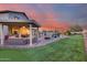 Expansive backyard features putting green, pool, covered patio, outdoor seating, and meticulous landscaping at 18103 W Canyon Ln, Goodyear, AZ 85338