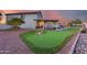 Lush backyard boasts putting green, covered patio, and meticulously designed landscaping at 18103 W Canyon Ln, Goodyear, AZ 85338