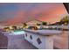 Outdoor kitchen overlooks a sparkling pool and is surrounded by lush desert landscaping at 18103 W Canyon Ln, Goodyear, AZ 85338