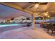 Inviting covered patio features ceiling fans, seating area, and dining space overlooking the sparkling pool at 18103 W Canyon Ln, Goodyear, AZ 85338