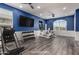 This staged exercise room features weights, gym equipment and blue walls at 38114 W San Clemente St, Maricopa, AZ 85138