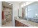 This bathroom features a granite counter top, a walk-in shower with tile surround, and a mirrored medicine cabinet at 4621 E Mineral Rd, Phoenix, AZ 85044