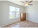 Bright bedroom featuring terracotta tile flooring, a ceiling fan, and a window with views of the front yard at 4621 E Mineral Rd, Phoenix, AZ 85044