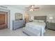 Bright bedroom featuring a dresser, nightstands, ceiling fan and a large window at 4621 E Mineral Rd, Phoenix, AZ 85044