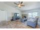 Cozy living room featuring a ceiling fan, entertainment center, brick fireplace, and tiled floors at 4621 E Mineral Rd, Phoenix, AZ 85044