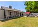 Large backyard featuring a covered patio, green grass, and outdoor kitchen at 6110 E Ivyglen St, Mesa, AZ 85205