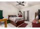 Comfortable bedroom with ceiling fan, tiled floors, and coordinating furniture at 6110 E Ivyglen St, Mesa, AZ 85205