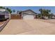 Wide driveway accessing the two-car garage and RV parking behind a wood fence with brick trim at 6110 E Ivyglen St, Mesa, AZ 85205