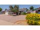 Landscaped front yard showcases mature shrubs and a single-story home with a brick-accented entryway at 6110 E Ivyglen St, Mesa, AZ 85205
