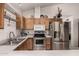 Well-equipped kitchen with stainless steel appliances, oak cabinets, and modern fixtures at 6110 E Ivyglen St, Mesa, AZ 85205