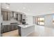Open kitchen boasts a large center island, gray cabinetry, and stainless steel appliances at 26992 W Melinda Ln, Buckeye, AZ 85396