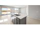Bright kitchen featuring a large island with sink, wood-look tile flooring, and sliding glass doors at 26992 W Melinda Ln, Buckeye, AZ 85396