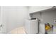A laundry room with washer, storage shelf, and light wood flooring at 26992 W Melinda Ln, Buckeye, AZ 85396