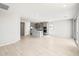 Spacious living room area showcasing open layout, kitchen with island and modern light fixtures at 26992 W Melinda Ln, Buckeye, AZ 85396
