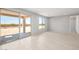 Bright living room with sliding glass doors leading to the backyard and light wood-look tile flooring at 26992 W Melinda Ln, Buckeye, AZ 85396