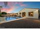 Exterior view of the home featuring a stunning backyard with a pool, firepit, outdoor kitchen, and patio at 3574 E Tonto Pl, Chandler, AZ 85249
