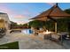 Backyard with pool, covered seating, fire pit, and lush landscaping at twilight at 3574 E Tonto Pl, Chandler, AZ 85249
