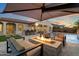 Backyard with a pool, fire pit, covered seating, and an outdoor kitchen at 3574 E Tonto Pl, Chandler, AZ 85249