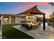 Outdoor living at its finest with a fire pit, pool, kitchen, and lush green turf at 3574 E Tonto Pl, Chandler, AZ 85249
