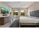 Well-lit main bedroom featuring backyard access, tile floors, and a dresser with a television at 3574 E Tonto Pl, Chandler, AZ 85249