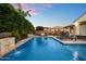 Gorgeous backyard with a pool, waterfall feature, and an outdoor bar at twilight at 3574 E Tonto Pl, Chandler, AZ 85249