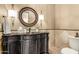 Elegant powder room featuring a vintage vanity with round mirror and sconce lighting at 36075 N Summit Dr, Cave Creek, AZ 85331