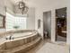 A luxurious bathroom featuring an oval soaking tub and glass block window for natural light at 36075 N Summit Dr, Cave Creek, AZ 85331