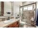 Modern bathroom featuring a tiled walk-in shower with glass door and neutral stone countertops and vanity at 36075 N Summit Dr, Cave Creek, AZ 85331