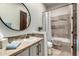 Well-lit bathroom featuring a round mirror, tile accents, and a shower-tub combo with neutral colors at 36075 N Summit Dr, Cave Creek, AZ 85331