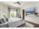 Bright bedroom with a large window and a big screen TV hanging on the wall at 36075 N Summit Dr, Cave Creek, AZ 85331