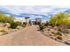 Attractive home with a paver driveway, lush desert landscaping, and unique architectural details at 36075 N Summit Dr, Cave Creek, AZ 85331