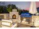 Outdoor kitchen with a stone fireplace, stainless steel grill, and comfortable patio seating with scenic views at 36075 N Summit Dr, Cave Creek, AZ 85331