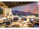 Covered patio with mountain views, featuring comfortable seating around a coffee table next to pool at 36075 N Summit Dr, Cave Creek, AZ 85331