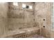 Detailed tile shower with a built-in bench and glass block window bringing in natural light at 36075 N Summit Dr, Cave Creek, AZ 85331