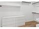 Bright walk-in closet features custom shelves, closet rod, drawers, and wood-look floors at 5756 N 78Th Pl, Scottsdale, AZ 85250