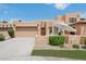 Beautiful home featuring a tan exterior, a two-car garage, and a charming front patio with an umbrella and chairs at 5756 N 78Th Pl, Scottsdale, AZ 85250