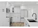 Well-lit kitchen featuring stainless steel appliances, a modern cooktop, and stylish white cabinetry at 5756 N 78Th Pl, Scottsdale, AZ 85250