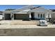 An exterior view of a new home with a three car garage and covered porch at 6452 E Omega Cir, Mesa, AZ 85215