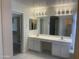 Bright bathroom with double sinks, vanity area, updated lighting, and spacious walk-in closet at 8009 S 53Rd Ave, Laveen, AZ 85339