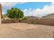Spacious backyard featuring a sand area, lush tree, and gravel landscaping for low maintenance at 10317 E Kiva Cir, Mesa, AZ 85209