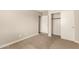 This bedroom features neutral carpeting, a closet, and a door leading to another room at 10317 E Kiva Cir, Mesa, AZ 85209