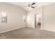 A carpeted bedroom with a ceiling fan and two windows at 10317 E Kiva Cir, Mesa, AZ 85209