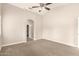 A large carpeted bedroom featuring a ceiling fan and an entry way at 10317 E Kiva Cir, Mesa, AZ 85209