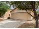 Beige home with a large two-car garage and low-maintenance desert landscaping at 10317 E Kiva Cir, Mesa, AZ 85209